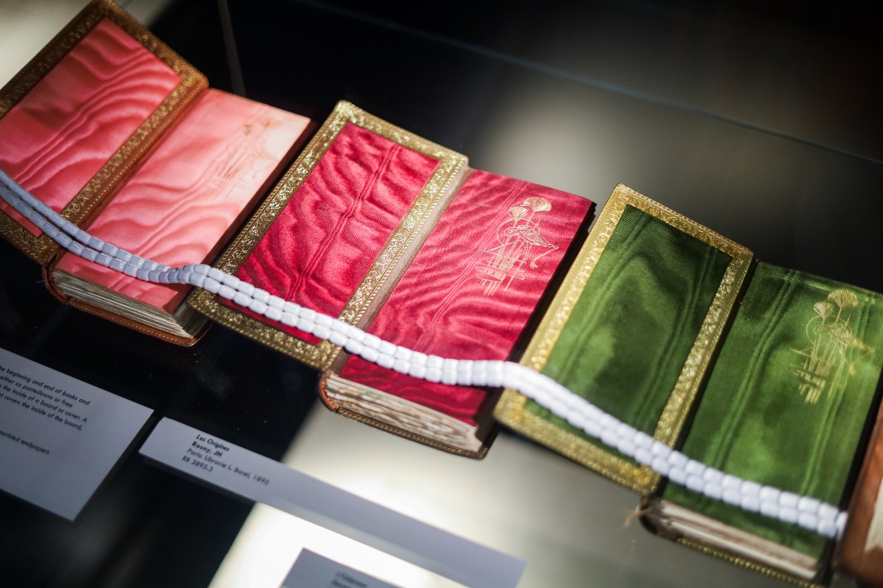 Three open book covers with luxurious pink, magenta and green fabric inside