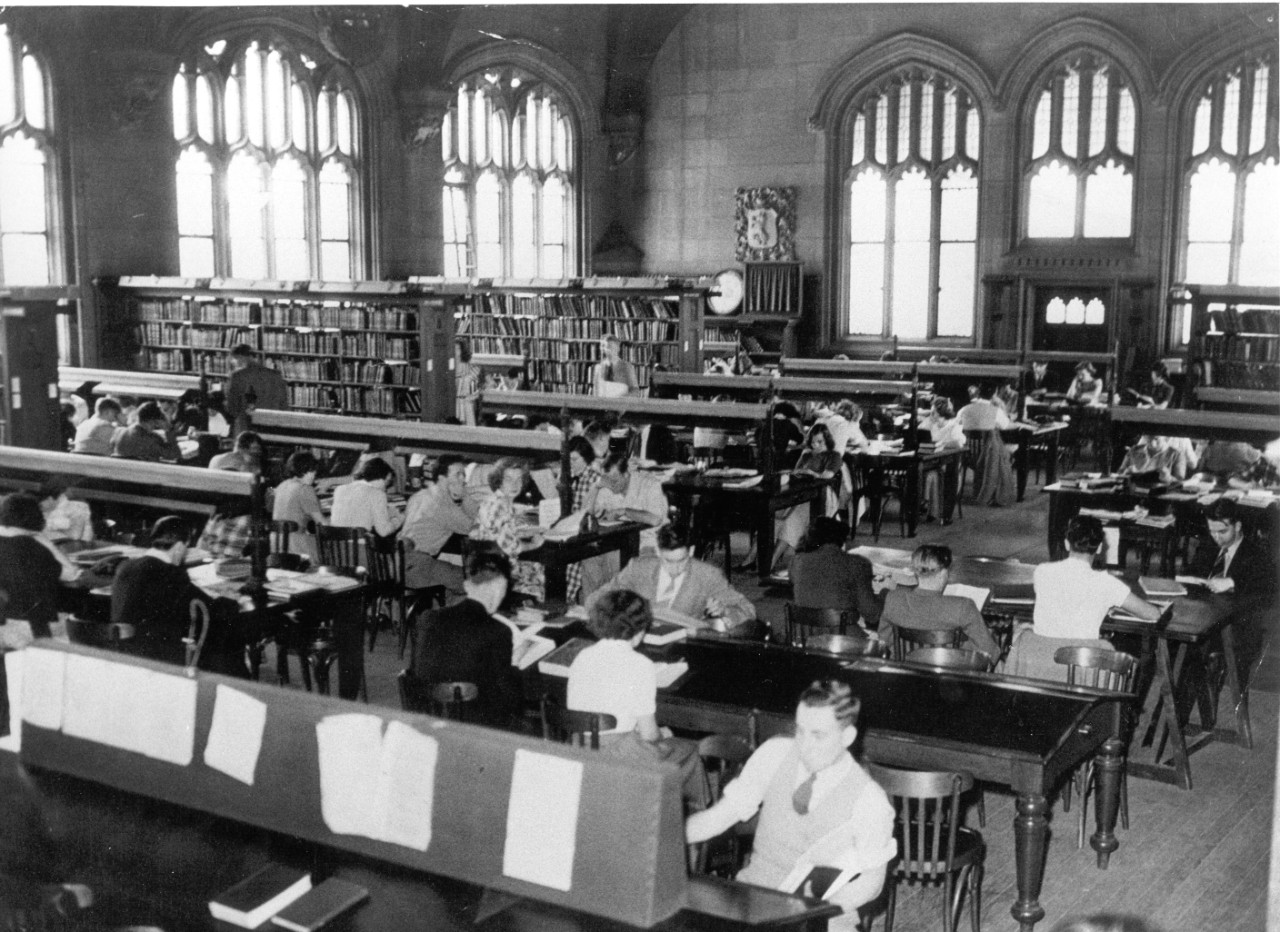 Black and white photo of students studying in a large hall