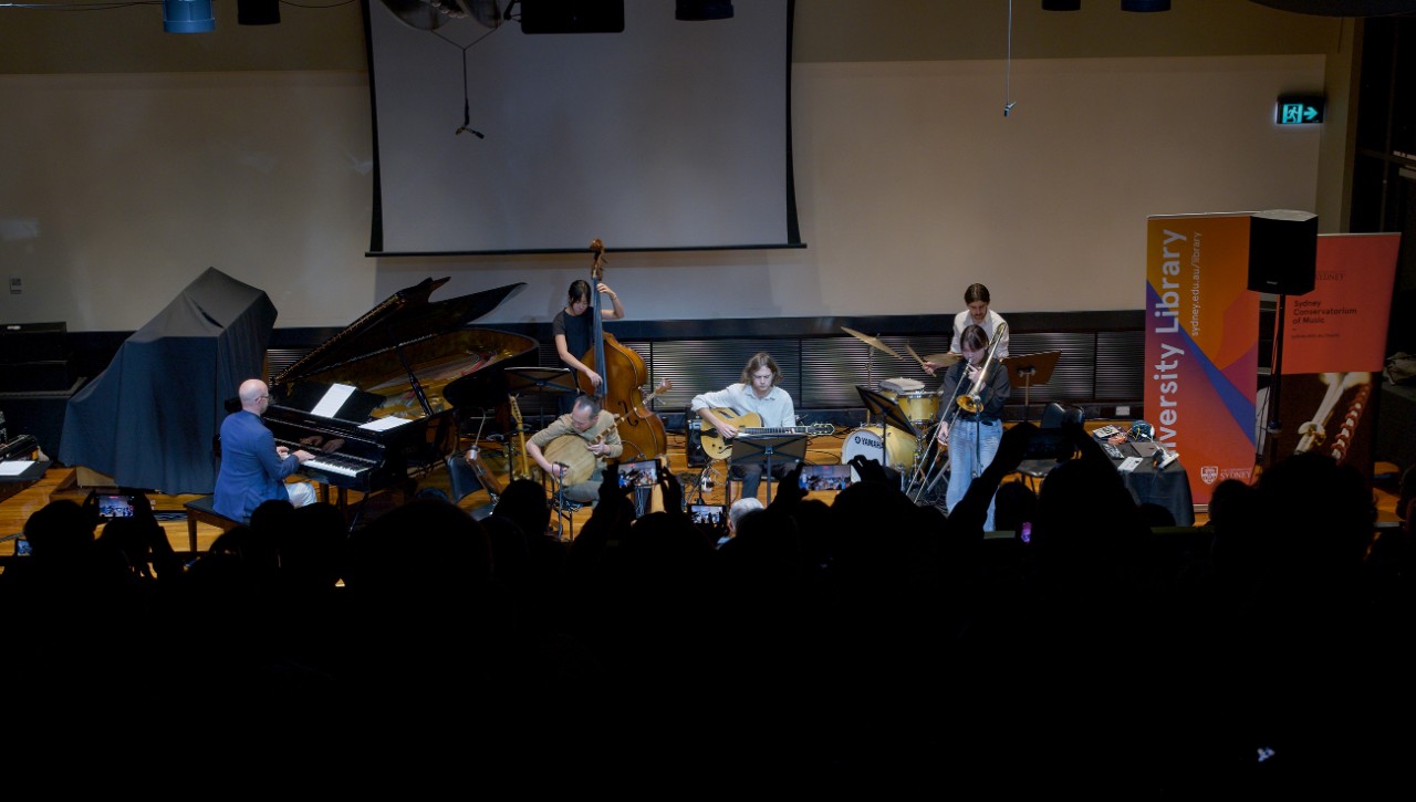 Six musicians on stage in front of an audience