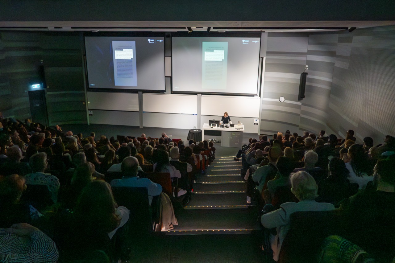Vanessa Smith presenting in front of a filled lecture theatre