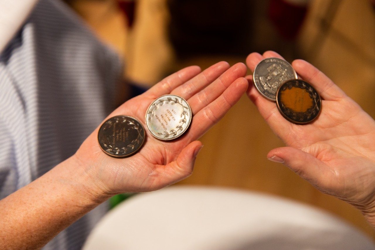 Close up of two hands each holding two large coins