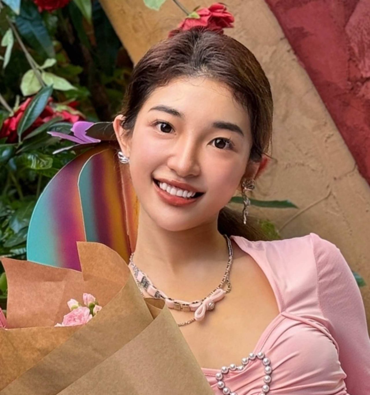a photograph of an female student posing with a bouquet of flowers
