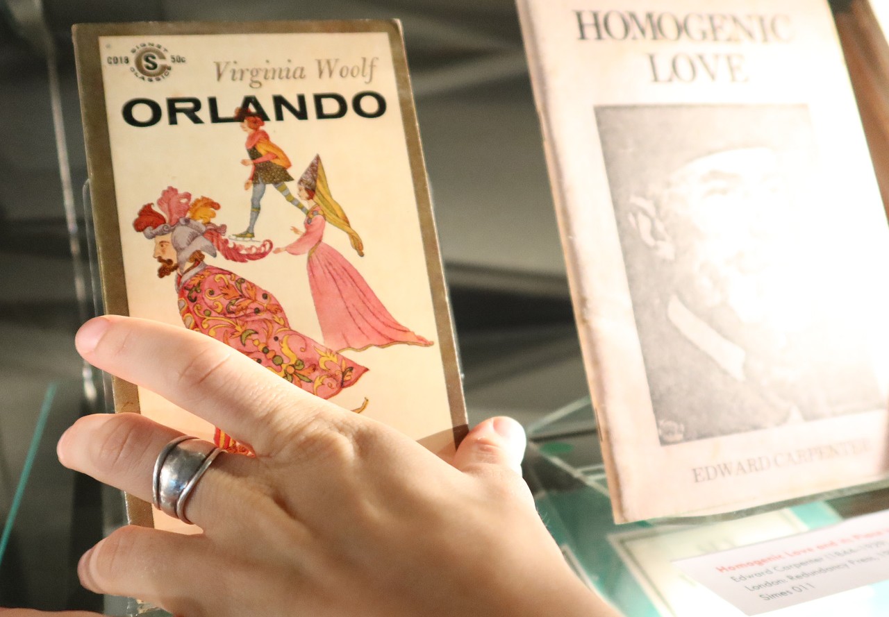 A close up shot of a hand reaching for the cover of 'Orlando' by Virgina Woolf 