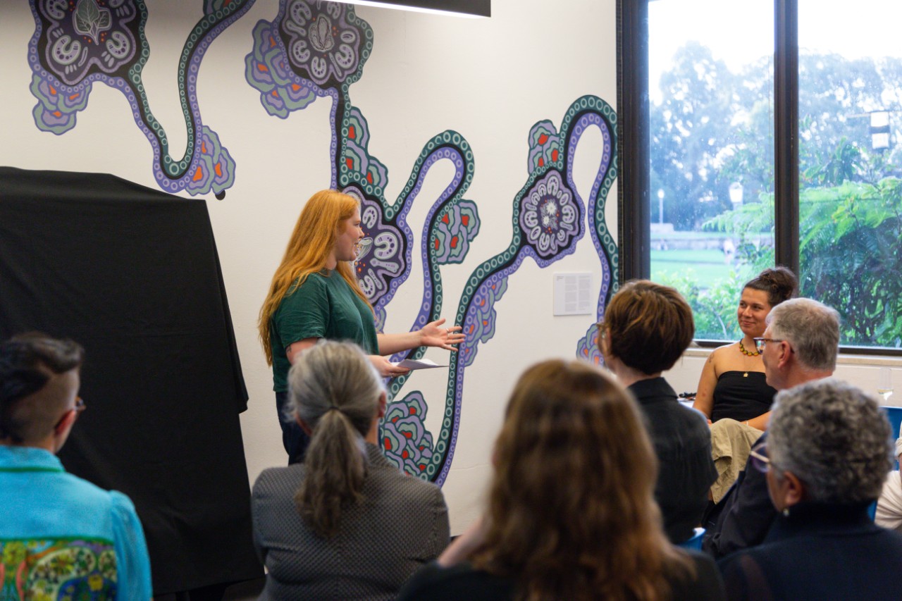 Pippa Herden giving a speech in front of seated attendees