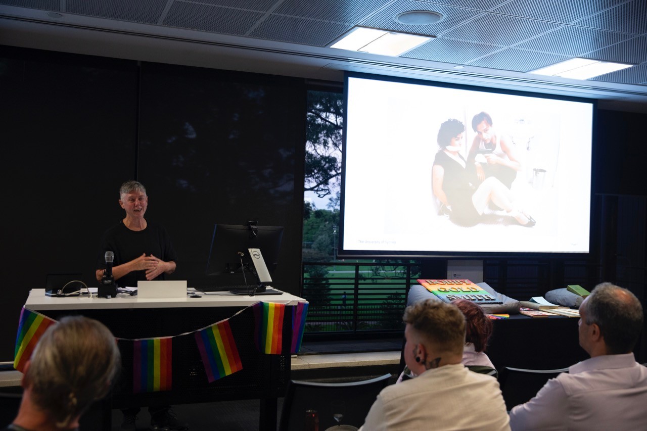 Professor Lee Wallace presenting in front of a seated crowd