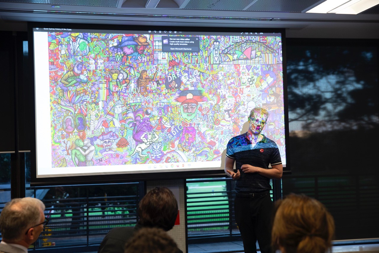 Artist Jeremy Smith speaking about his work in front of a crowd
