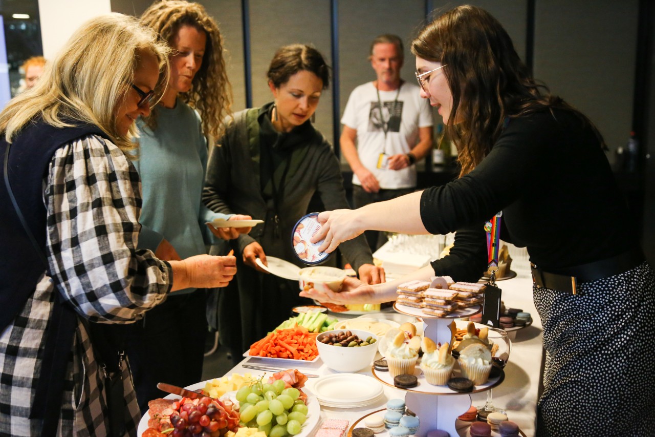 People gathered around a table of food and drinks