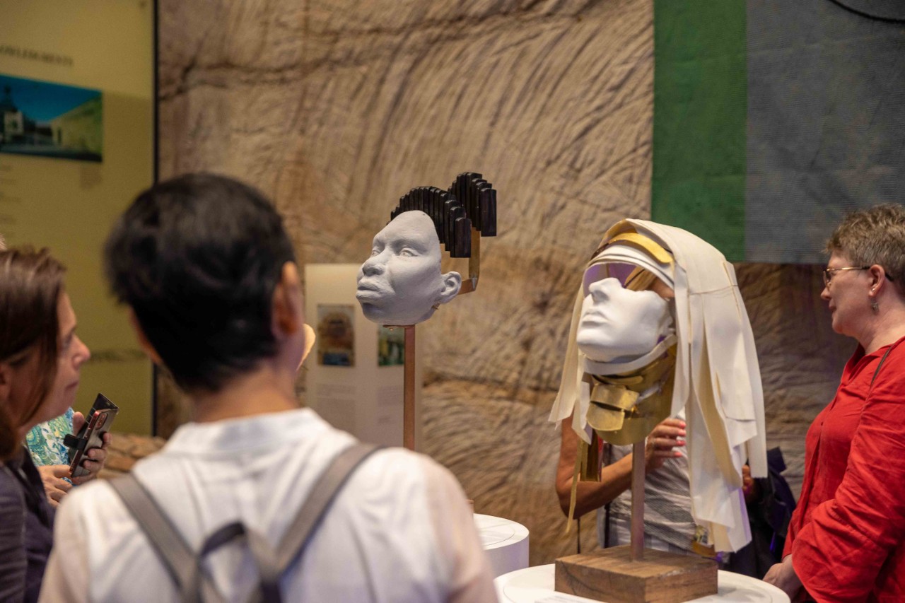 People looking at busts displayed on plinths